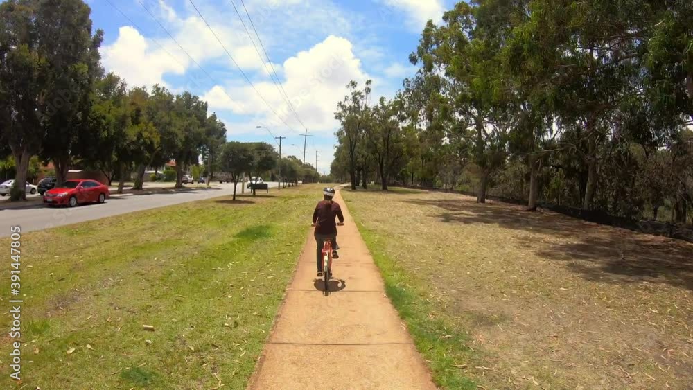 Hyperlapse - Rear view of an adult woman cycling on bicycle path Hyperlapse - Rear view of an adult woman cycling on bicycle path