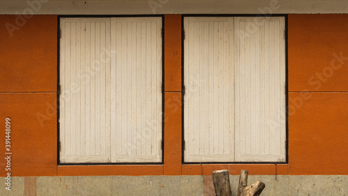 two wood windows on red brick wall