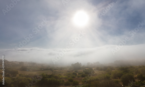 Morning mood after sunrise in southern Spain in Andalusia. A view from above of the castle of the clouds and the landscape east of the city of Medina Sidonia. Sun rays refract in the light.