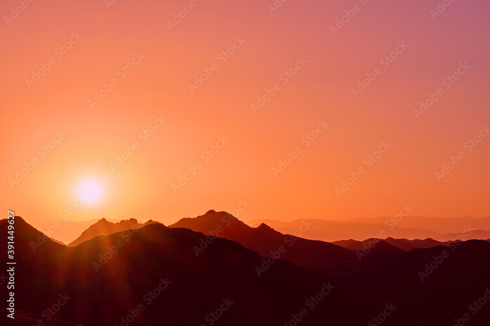 Rising sun over the mountain ridges as a background Rising sun over the mountain ridges as a background