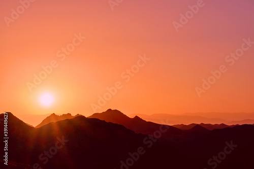 Rising sun over the mountain ridges as a background © kiwisoul