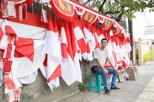 portrait of a young man selling the Indonesian national flag