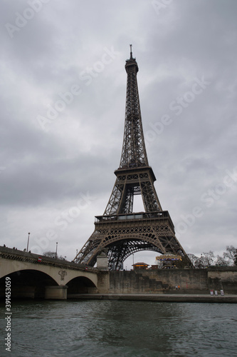 The Eiffel Tower seen from the Seine on a cloudy morning. Paris, France.