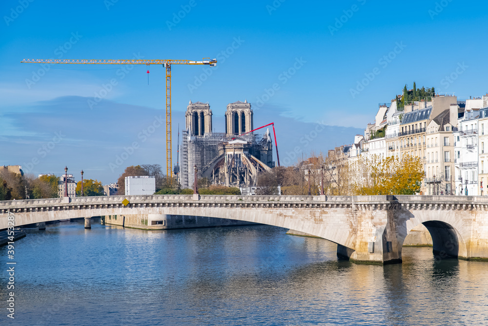    Paris, Notre-Dame cathedral under construction and the Tournelle bridge in the center, ile de la Cite 
