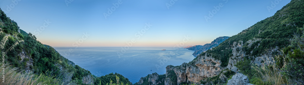 Panoramic view of Amalfi Coast, with Positano seaside village and beach, leisure boats moored in a bay and scenic cliffs from famous hiking path of the Gods in Campany, Italy Panoramic view of Amalfi Coast, with Positano seaside village and beach, leisure boats moored in a bay and scenic cliffs from famous hiking path of the Gods in Campany, Italy