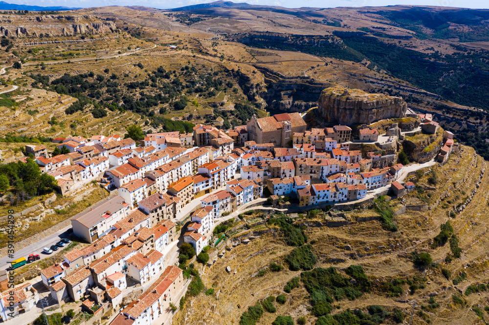 View from drone of Ares del Maestrat, small ancient town on mountain slopes on sunny fall day, Spain