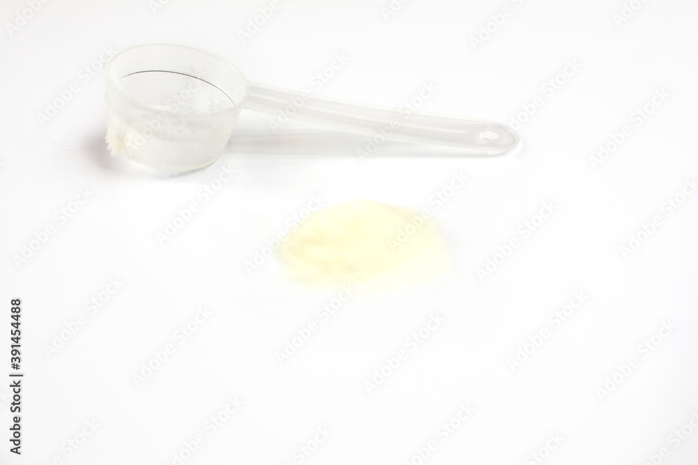 cologen powder for face rejuvenation with measuring spoon on white background