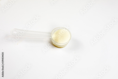 cologen powder for face rejuvenation in a serving spoon on a white background