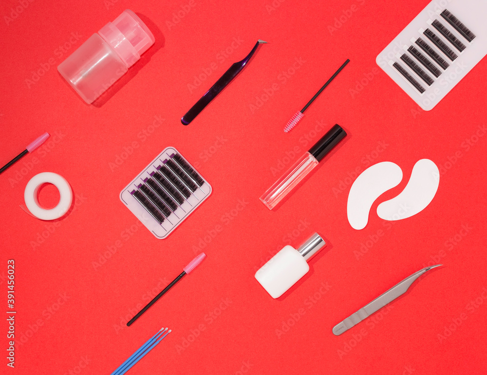 Tools for eyelash extension on an orange background, top view. Artificial eyelashes, tweezers, microbrushes, patches and brushes for lashmaker. Tools for eyelash extension on an orange background, top view. Artificial eyelashes, tweezers, microbrushes, patches and brushes for lashmaker.