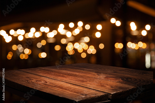 Vintage wooden table on blurred golden bokeh on a dark background. Cafe-dining-restaurant.