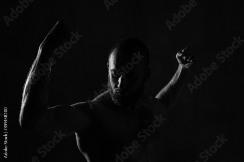 Low-key studio shot of muscular man