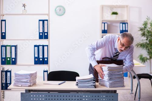 Old male employee unhappy with excessive work in the office