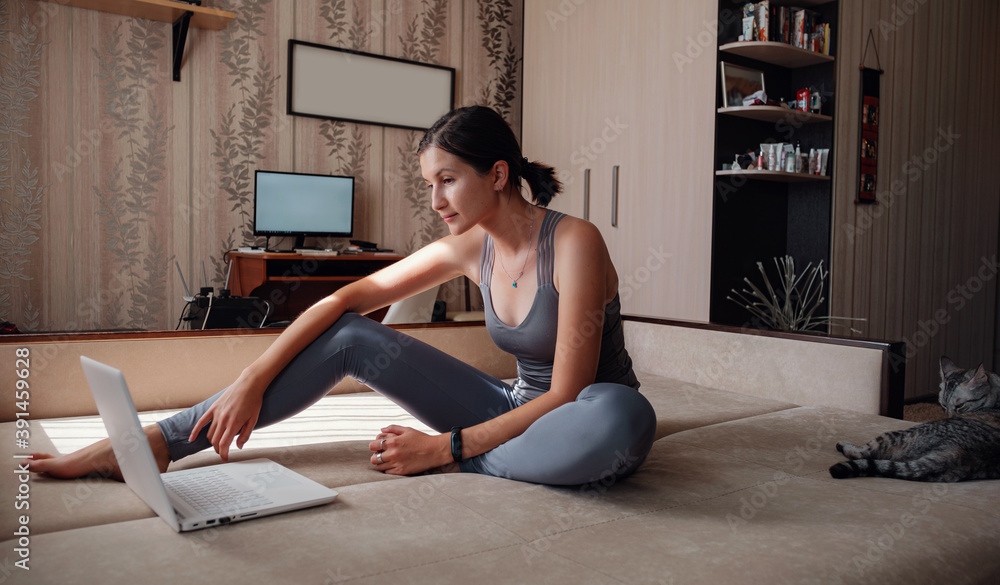 Young attractive smiling woman practicing yoga, sitting in Half Lotus exercise Young attractive smiling woman practicing yoga, sitting in Half Lotus exercise