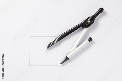 Pair of compasses draw a square on a paper