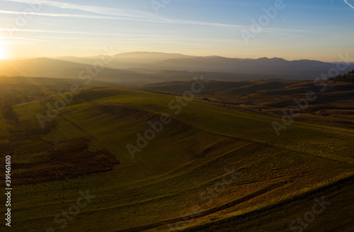 Aerial view of sunset above green hills