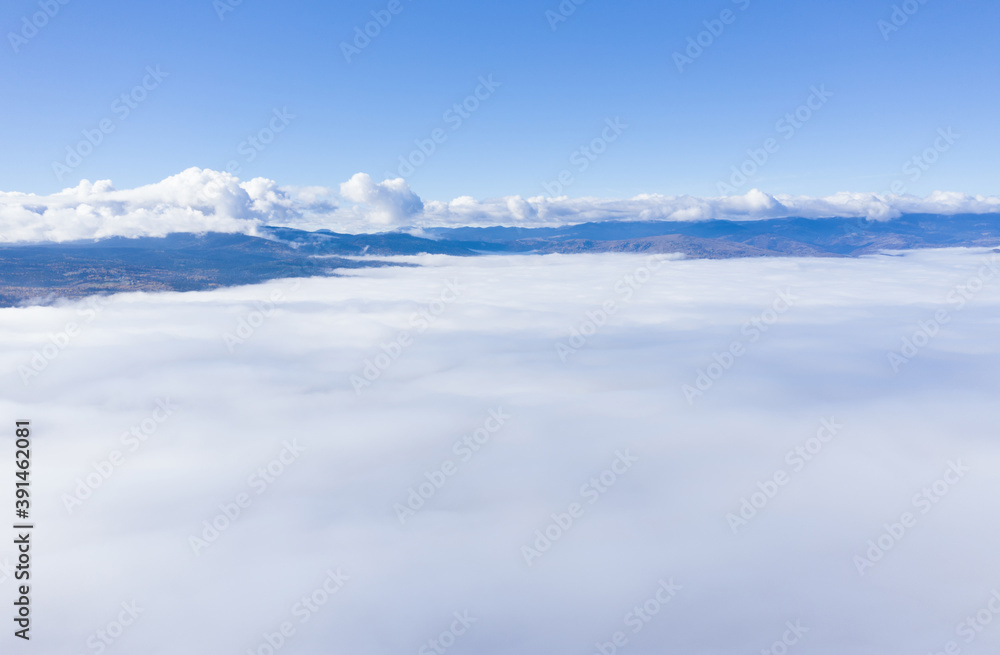 Aerial drone shot of flying above clouds