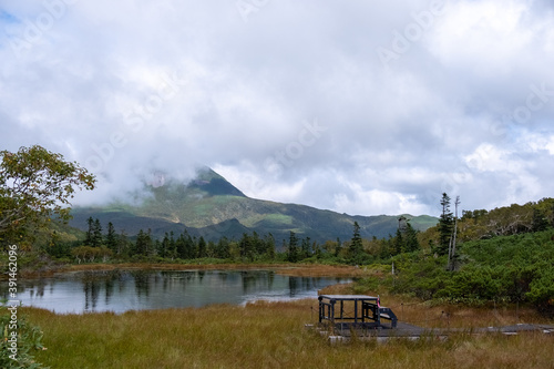 View of one of four marsh lakes around Lake Rausu with mountains reflected in lake