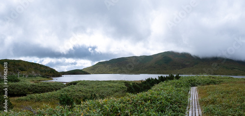 Panoramic view of Lake Rausu, a footpath and mountain ranges photo