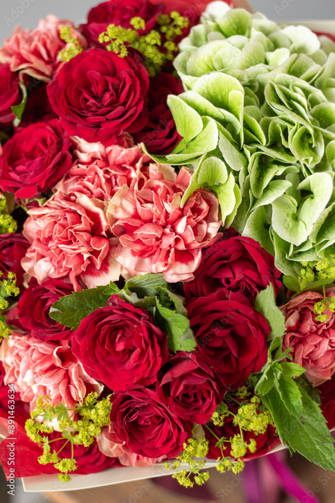 Red and green flowers. Autumn bouquet of mixed flowers in glass vase on wooden table. The work of the florist at a flower shop. Fresh cut flower. Red and green flowers. Autumn bouquet of mixed flowers in glass vase on wooden table. The work of the florist at a flower shop. Fresh cut flower.