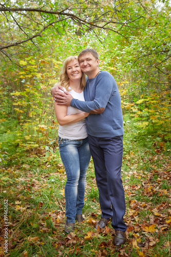 Middle-aged couple walking in the park on an autumn day.