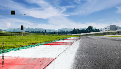 Motor sport circuit asphalt track background kerbs close up on straight and green field © fabioderby