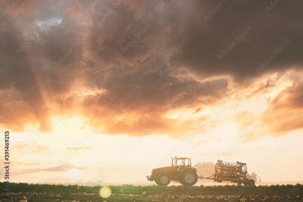 Tractor On Road In Spring Season. Beginning Of Agricultural Spring Season. Cultivator Mounted On Tractor In Countryside Rural Field Landscape. Sunny Spring Sunset Sunrise Sky Tractor On Road In Spring Season. Beginning Of Agricultural Spring Season. Cultivator Mounted On Tractor In Countryside Rural Field Landscape. Sunny Spring Sunset Sunrise Sky