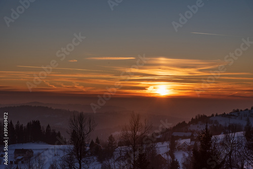 Sunset with colorful sky from Koczy Zamek hill in winter Beskid Slaski mountains in Poland