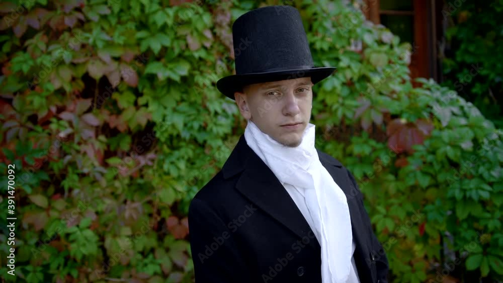 Handsome Young Man Wearing A Frock-Coat And A Top Hat Taking Off His Face Mask Handsome Young Man Wearing A Frock-Coat And A Top Hat Taking Off His Face Mask