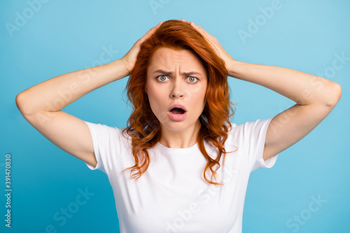 Photo portrait of scared worried girl holding head with two hands isolated on pastel blue colored background