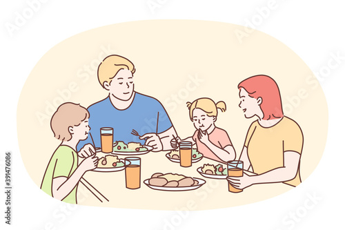 Happy family having dinner or breakfast together at home. Smiling family father mother and children cartoon characters sitting and eating healthy meal at table together at home. Clean homemade eating