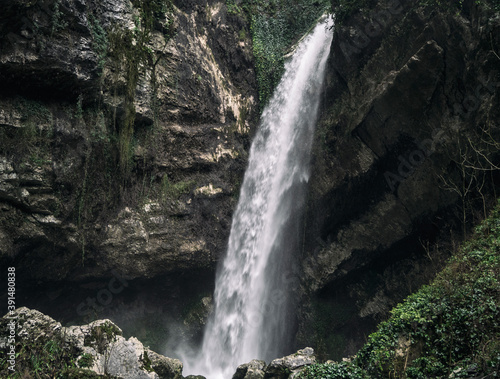 Waterfall flowing from rocky stone wall