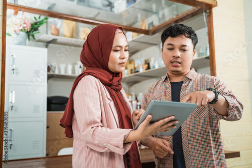 portrait young man and muslim woman talking about product sales photo