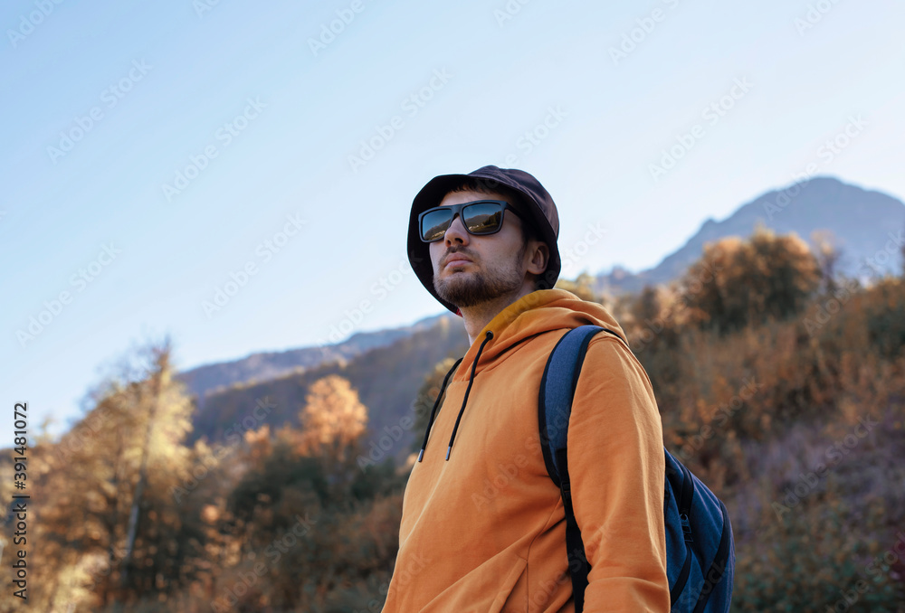 A young man is traveling in the mountains.