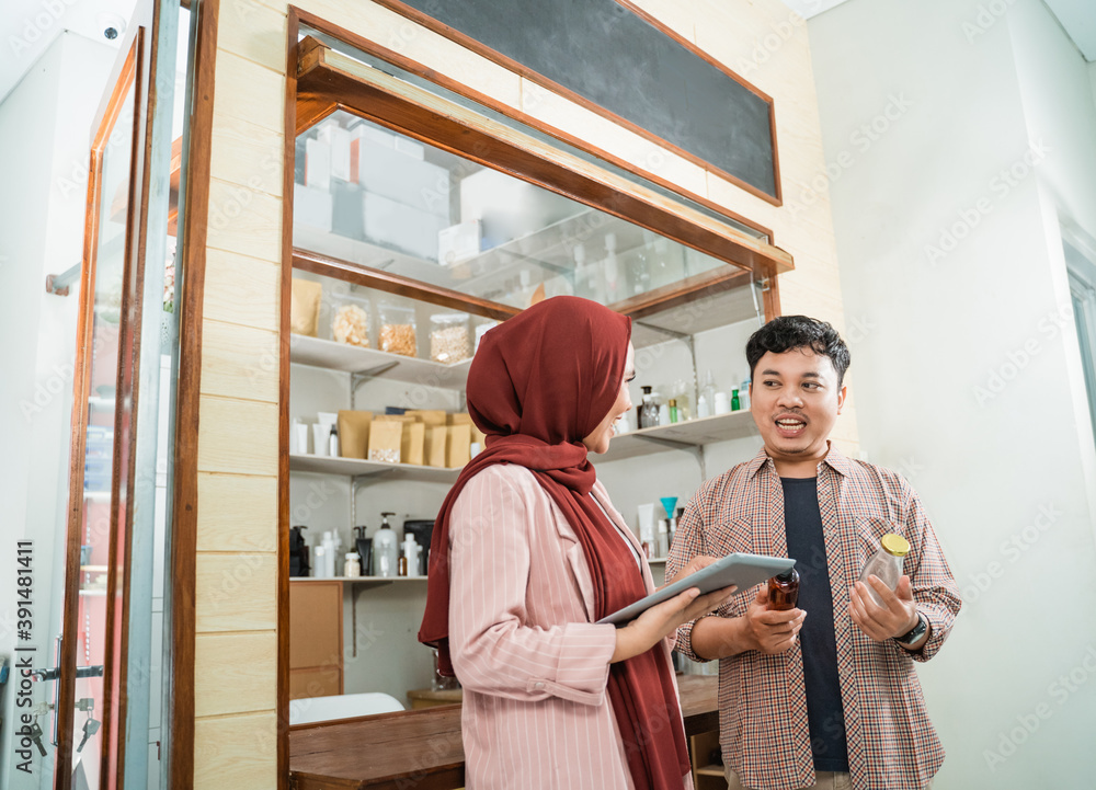 Obraz premium portrait young man and muslim woman talking about product sales