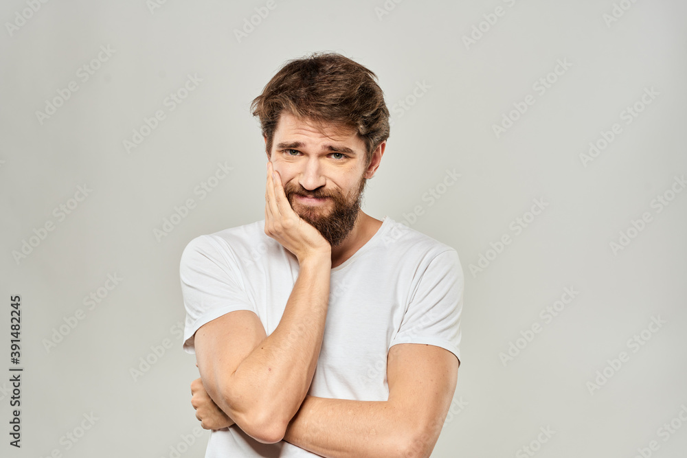 man in white t-shirt gesturing with his hands studio dissatisfaction lifestyle light background man in white t-shirt gesturing with his hands studio dissatisfaction lifestyle light background