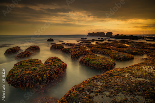 Amazing seascape. Beach with rocks and stones. Low tide. Motion water. Slow shutter speed. Soft focus. Mengening beach, Bali, Indonesia