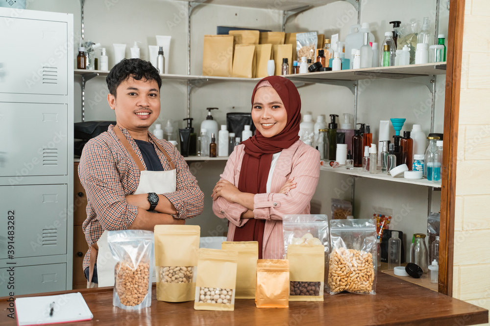portrait young man and muslim woman selling packaged products paper and plastic portrait young man and muslim woman selling packaged products paper and plastic