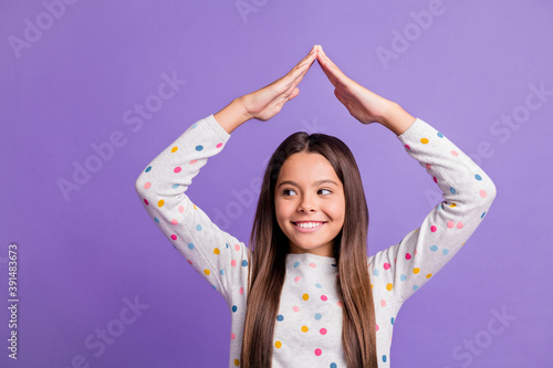 Photo portrait of girl making roof with hands looking to side isolated on bright purple colored background