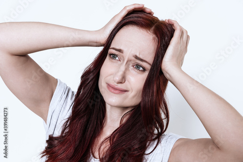 Woman holds hands on her head and feels headache.