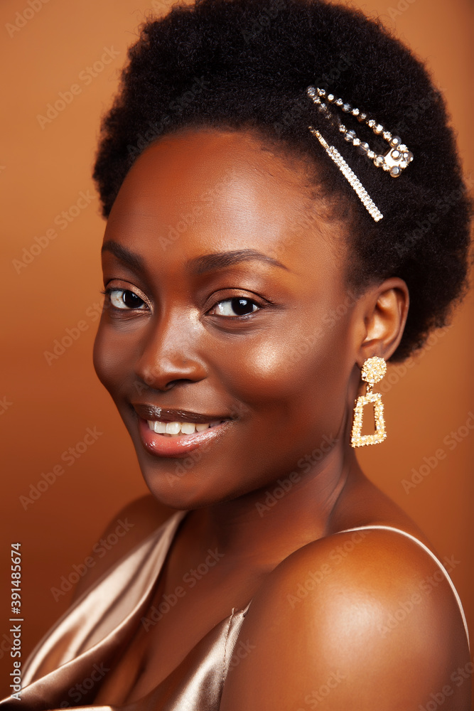 young pretty african model with golden jewelry in fashion style dress smiling happy on brown backround, lifestyle people concept young pretty african model with golden jewelry in fashion style dress smiling happy on brown backround, lifestyle people concept