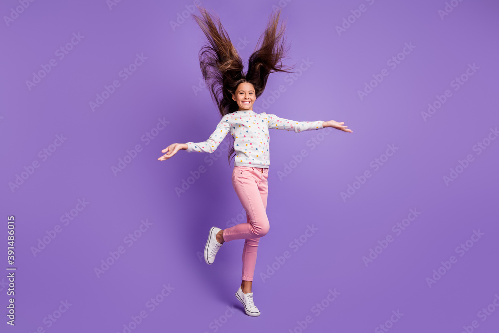 Full length body size photo schoolgirl with long hair throwing in the air standing tiptoes smiling isolated on vivid violet color background Full length body size photo schoolgirl with long hair throwing in the air standing tiptoes smiling isolated on vivid violet color background