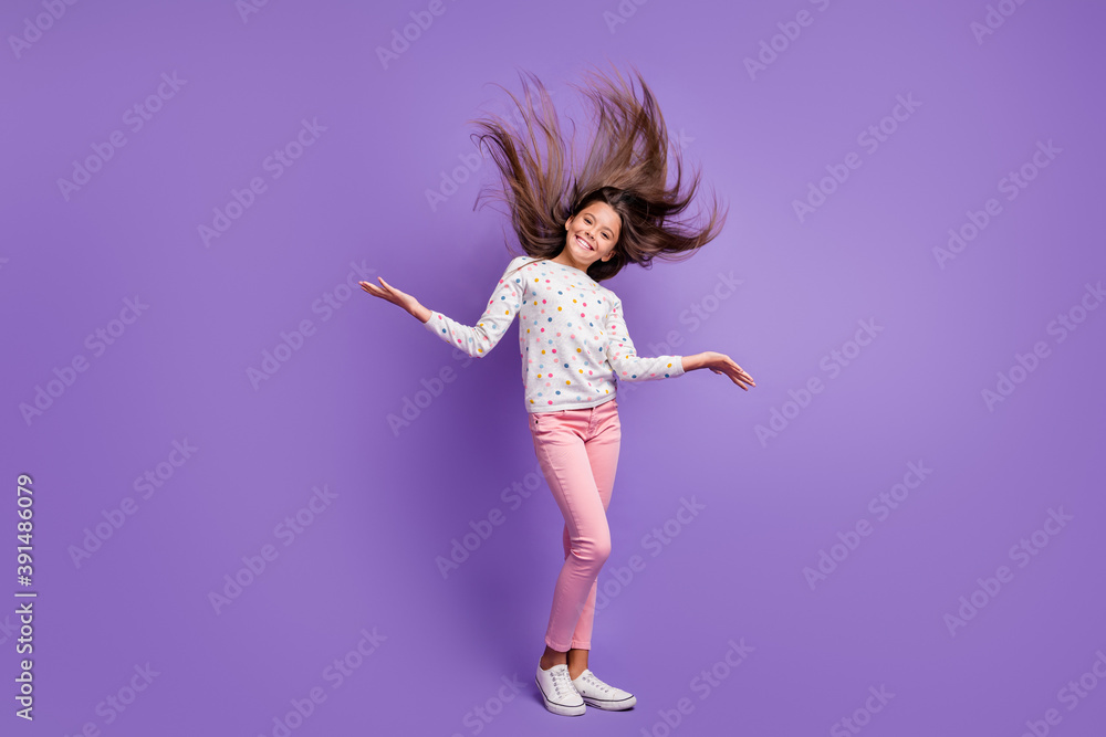 Full length body size photo small girl with long hair throwing in the air dancing smiling isolated on bright purple color background