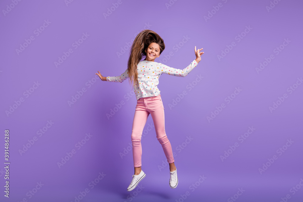 Full length body size photo schoolgirl laughing jumping throwing long hair air in casual outfit isolated on vibrant purple color background