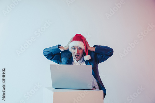 Beautiful smiling female model wear santa hat. Woman Santa hat. Celebration. Emotion. Laptop. Crazy photo. Working. 