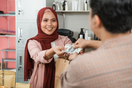 young men buy these packaged products to woman and make payment photo