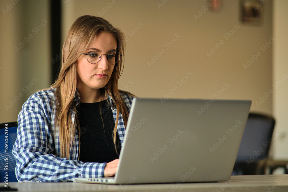 The programmer girl works at the computer Girls in science. In an empty office during a pandemic. The programmer girl works at the computer Girls in science. In an empty office during a pandemic.