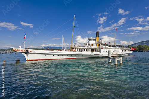 vintage steamboat arriving at a pier on Lake Geneva in Geneva Switzerland.