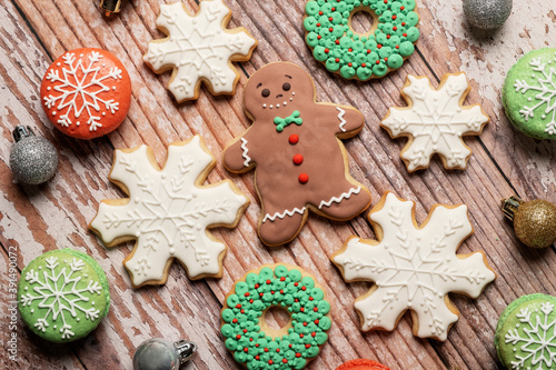Fototapeta Naklejka Na Ścianę i Meble -  Christmas cookies and gingerbread man cookies on a weathered wooden table background with icing and decorations.