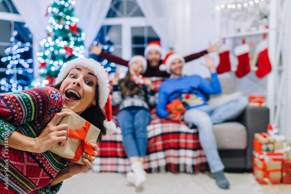 Group of friends having fun celebrating Christmas at home