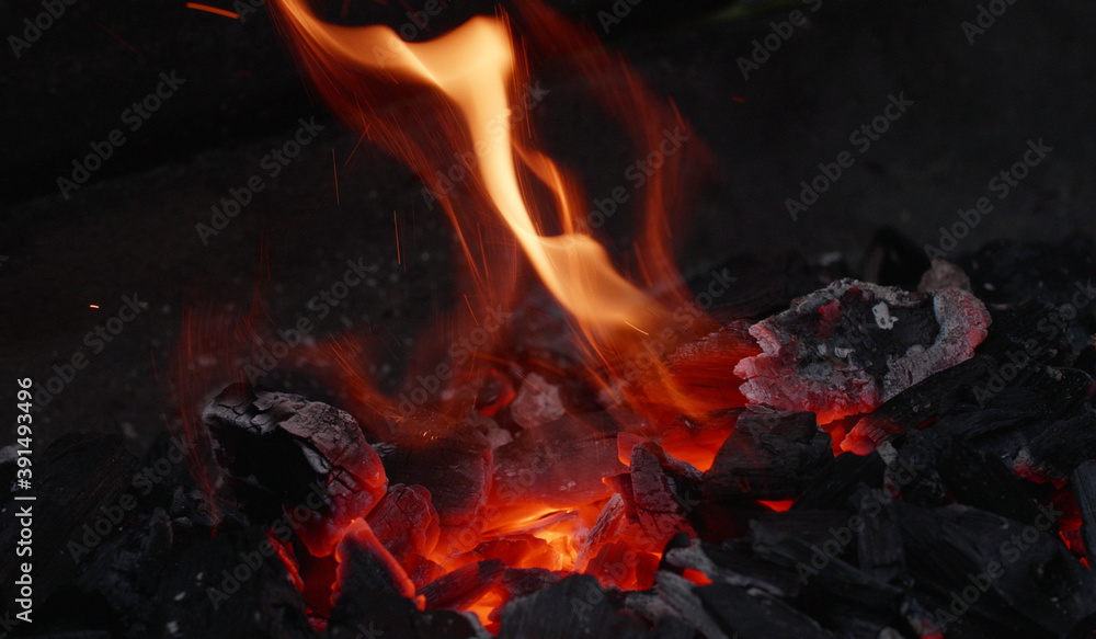 Dying and flying embers, glowing charcoal on a grill. barbecue in the garden, close-up of embers, grill in the garden Dying and flying embers, glowing charcoal on a grill. barbecue in the garden, close-up of embers, grill in the garden